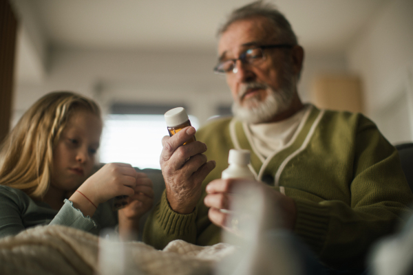 Senior man taking care of sick granddaughter.