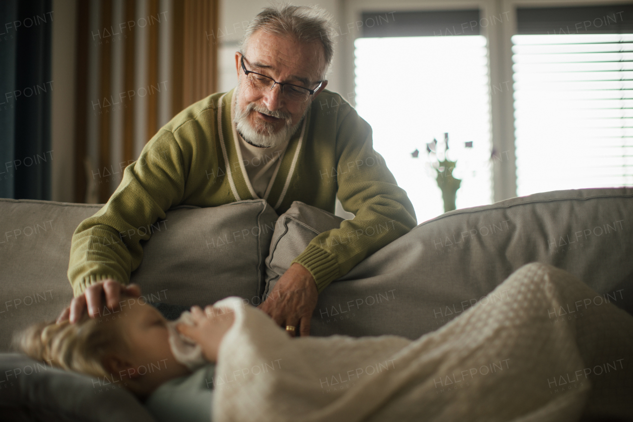 Senior man taking care of sick granddaughter.