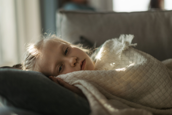 LIttle sick girl lying and sleeping in the bed.