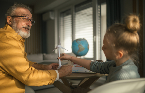 Senior man studying with his granddaughter.