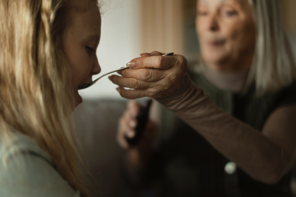 Senior woman taking care of sick granddaughter.