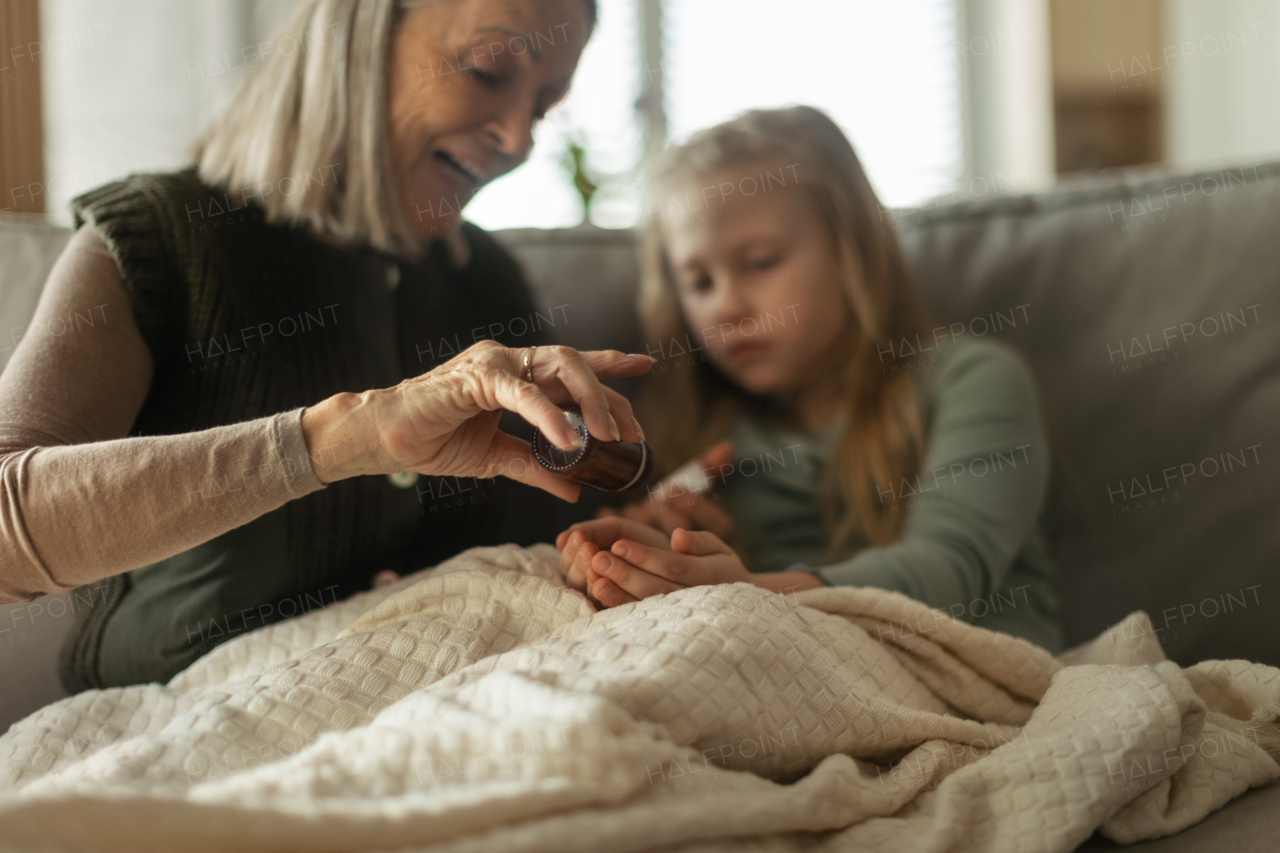 Senior woman taking care of sick granddaughter.