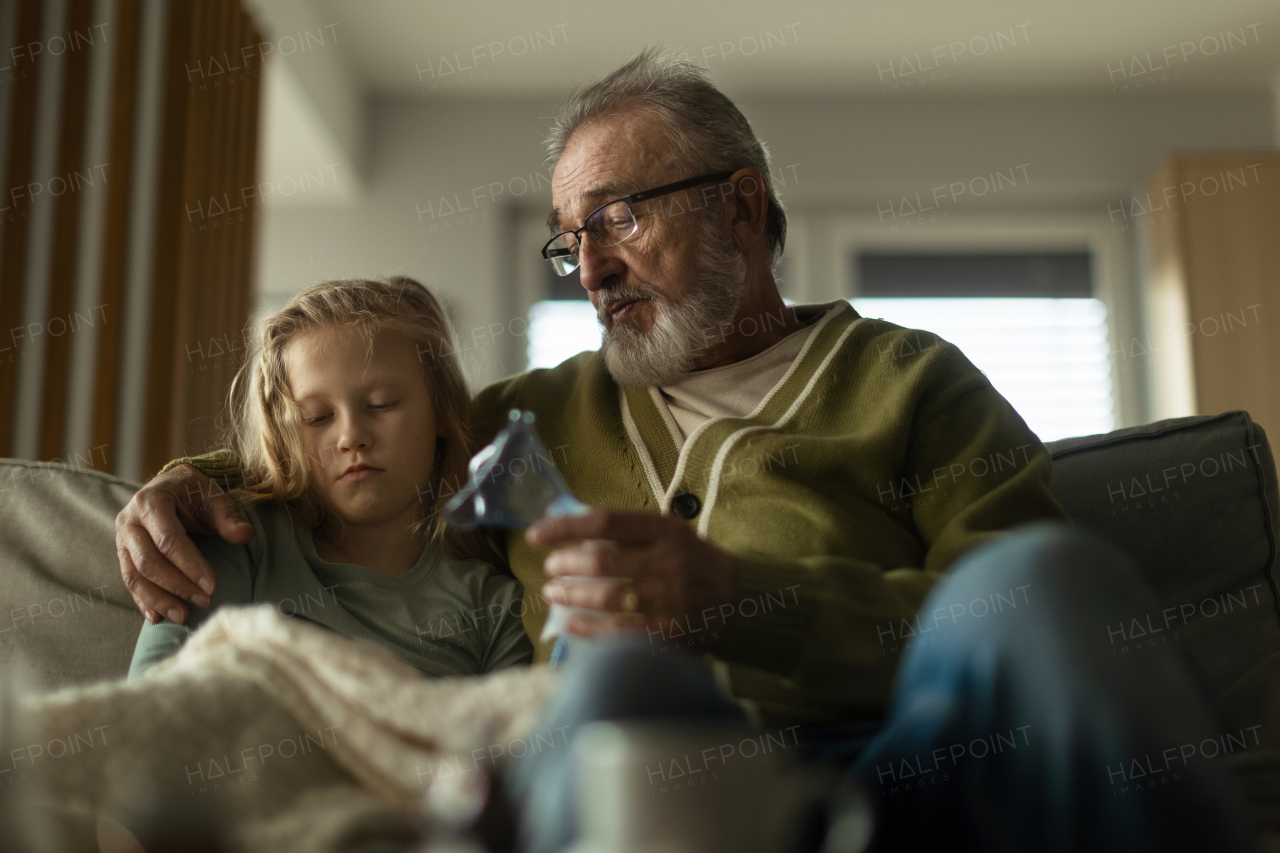 Senior man taking care of sick granddaughter.