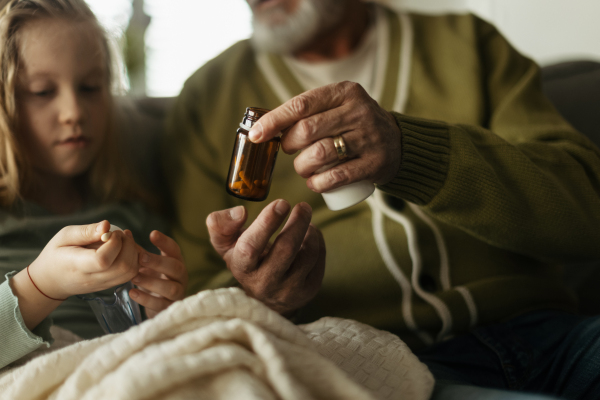 Senior man taking care of sick granddaughter.