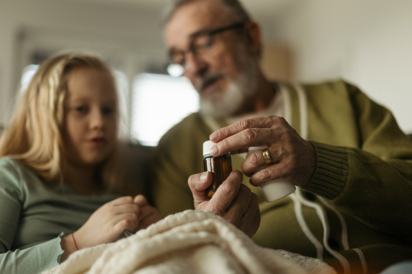 Senior man taking care of sick granddaughter.