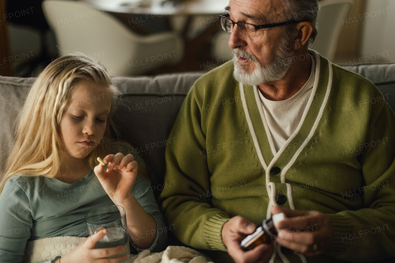 Senior man taking care of sick granddaughter.