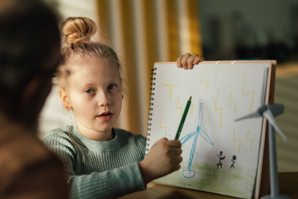 Little girl showing her image and explaining how working wind power.