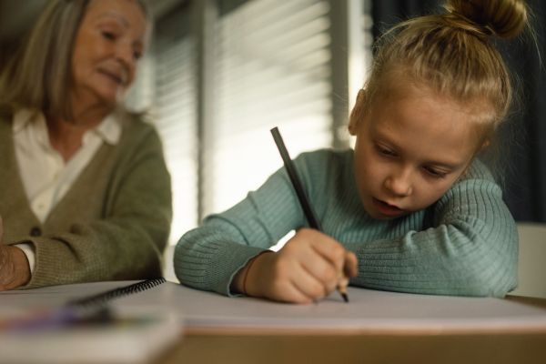 Senior man studying with his granddaughter.