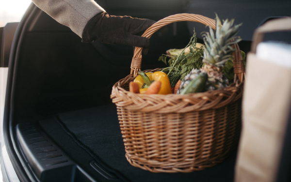 Close-up of somebody giving his purchase in the electric car trunk.