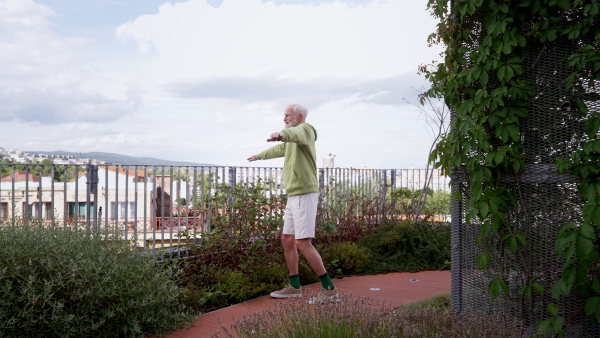 Senior man exercising outdoors in the city. An older, vital man leads an active lifestyle, going for a run every day.