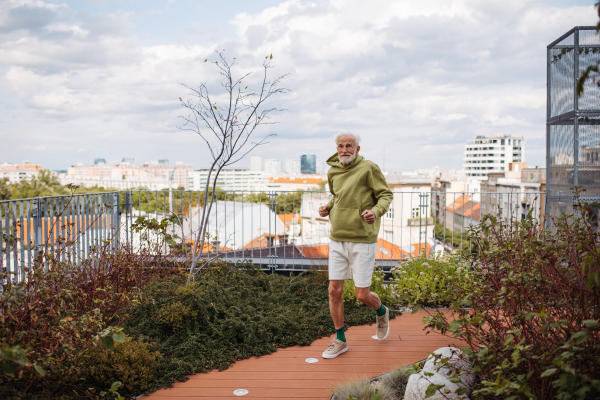 Senior man running outdoors in the city. An older, vital man leads an active lifestyle, going for a jog every day.