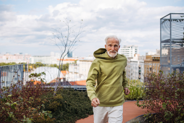 Senior man running outdoors in the city. An older, vital man leads an active lifestyle, going for a jog every day.