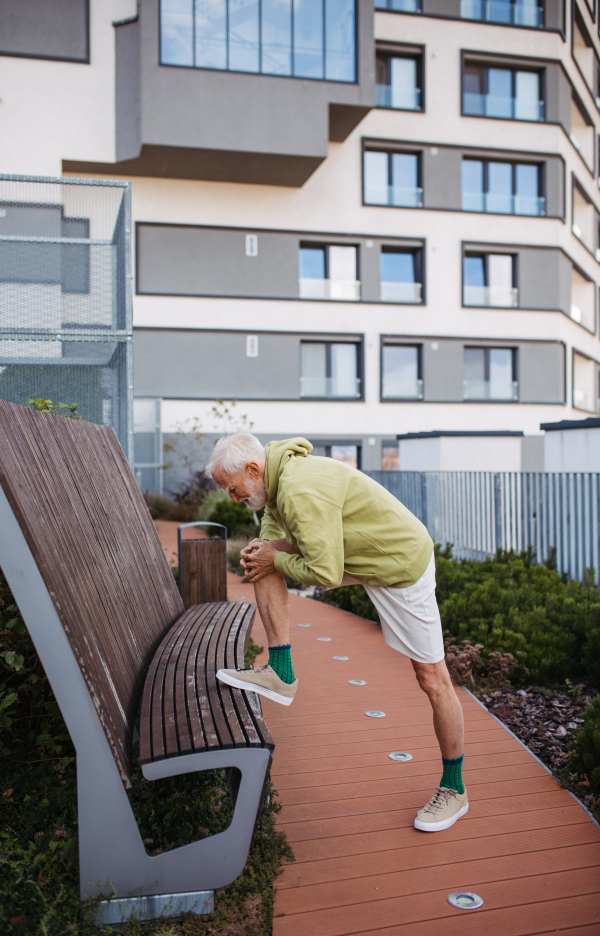 Senior man exercising outdoors in the city. An older, vital man leads an active lifestyle, going for a run every day.