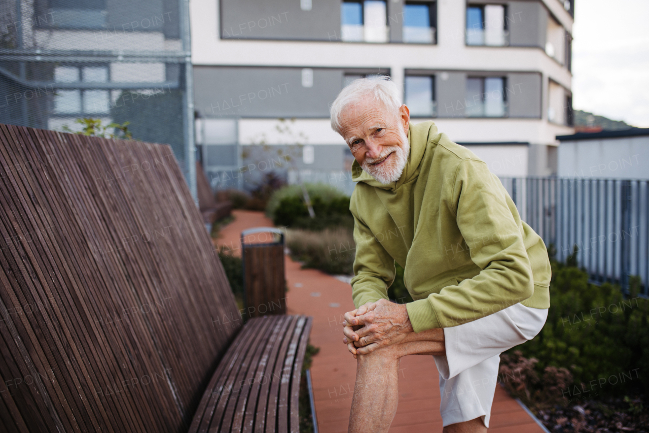 Senior man exercising outdoors in the city. An older, vital man leads an active lifestyle, going for a run every day.