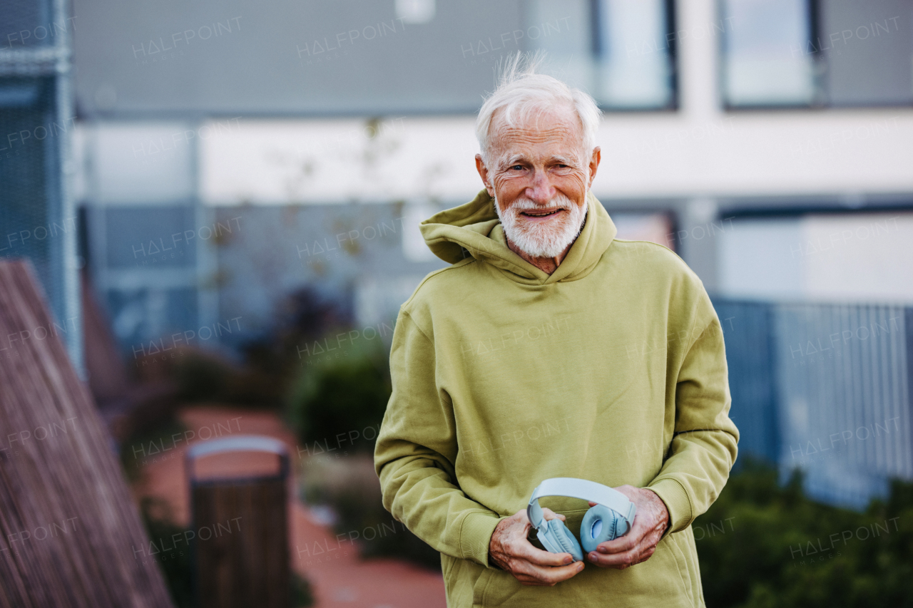 Portrait of elderly man preparing for his morning run. Senior man exercising outdoors in the city.