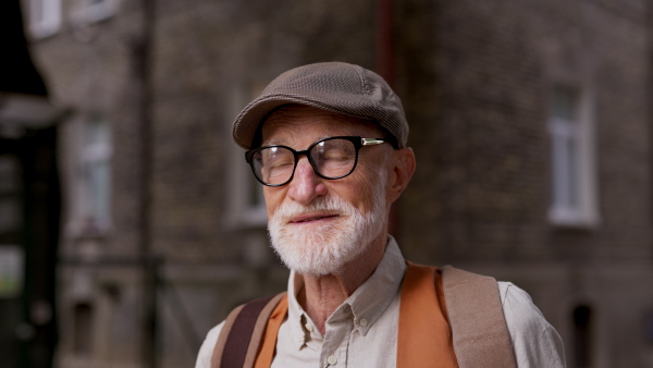 Video of a senior man with glasses and a beret on his head. Handsome smiling elderly man.