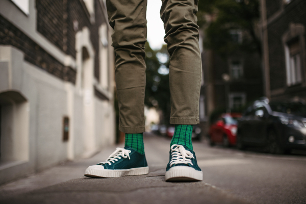 Close-up of a man's stylish shoes and quirky socks standing on the street in the city.