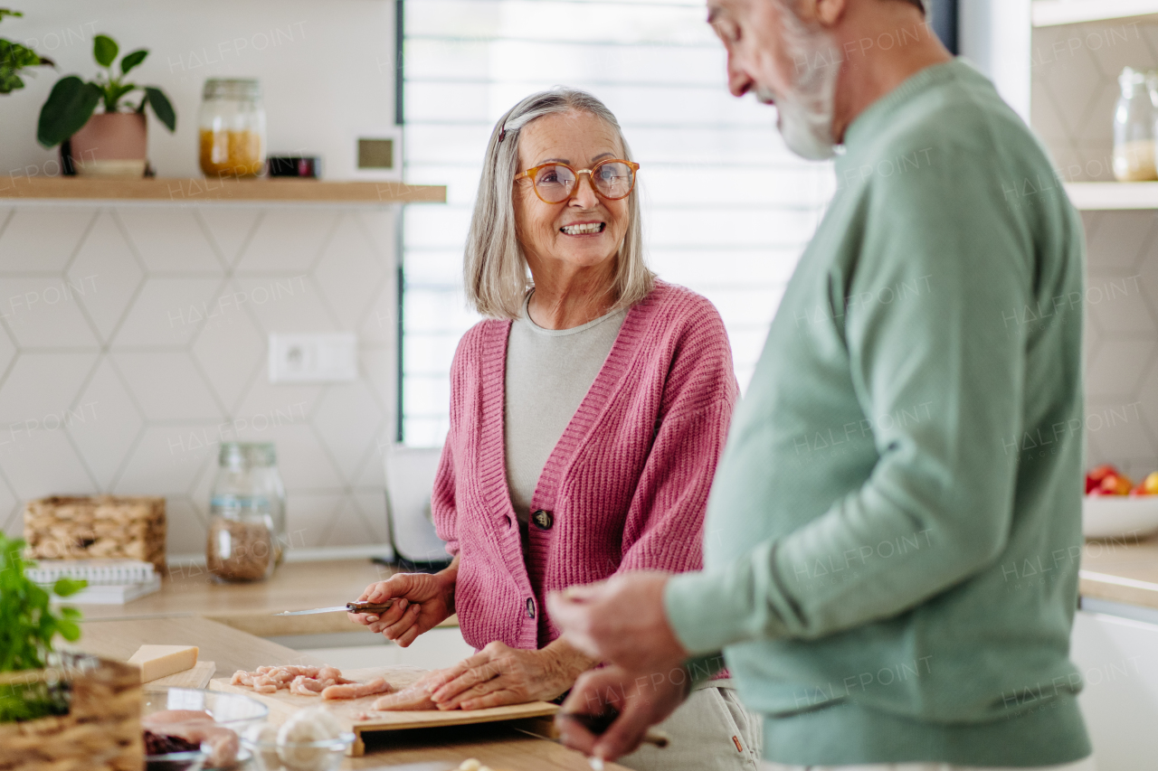 Senior couple cooking together in the kitchen.