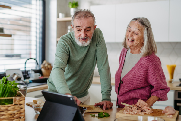 Senior couple cooking together in the kitchen.