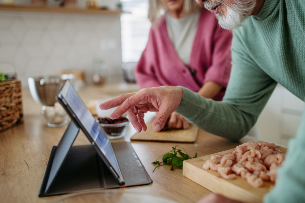 Senior couple cooking together in the kitchen.