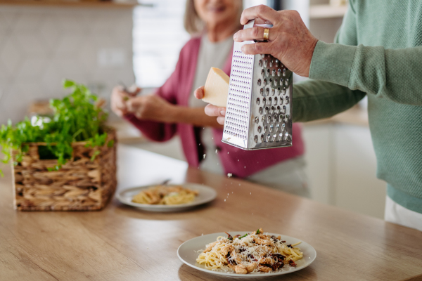 Close up of senior couple preparing lunch together.