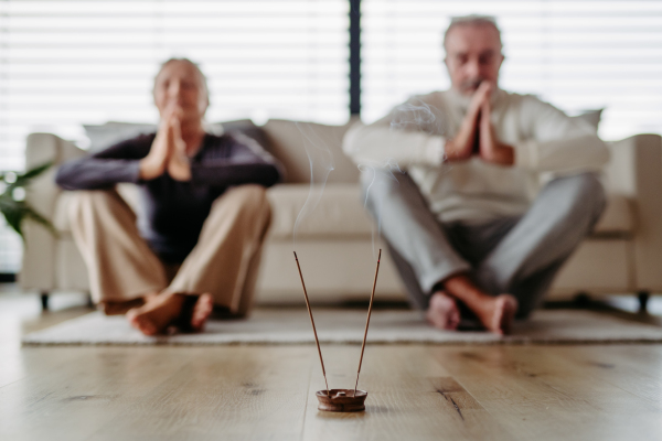 Senior couple meditating together in their apartment.