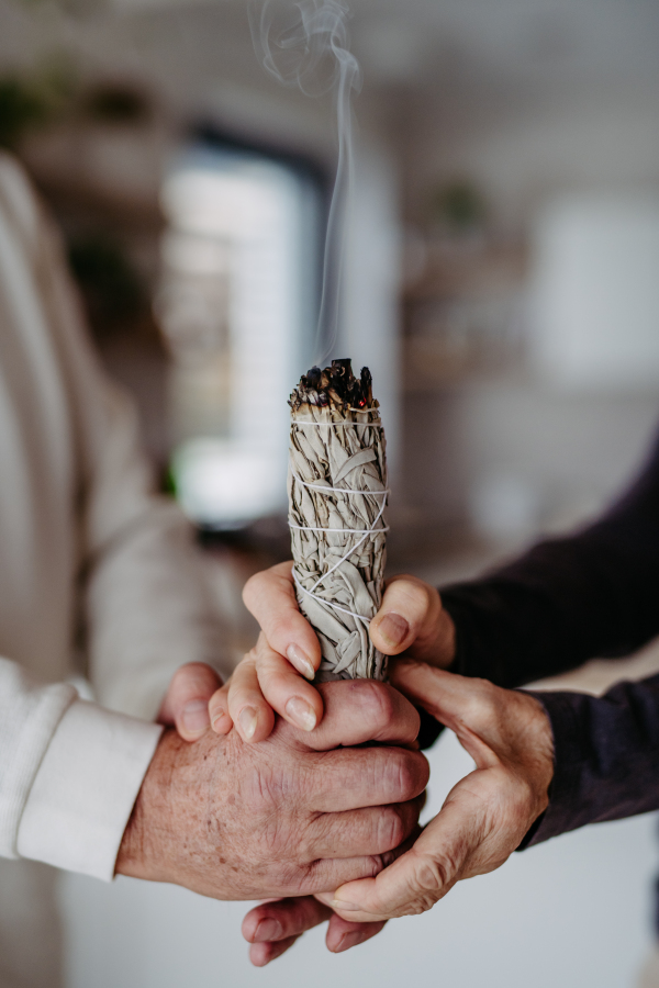 Close up of senior couple doing ritual with a sage.