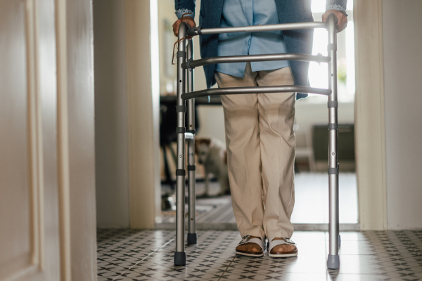 Low section of senior woman with walker at home.