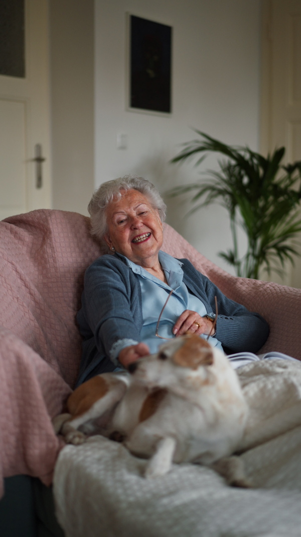 Senior woman enjoying time with her little dog at home.