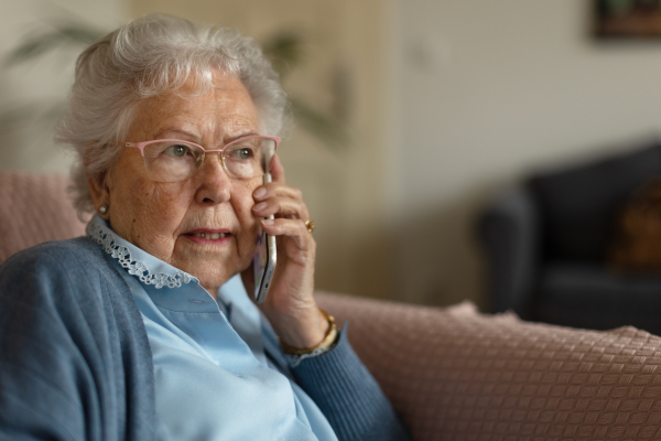 Portrait of a senior woman sitting at home and calling.