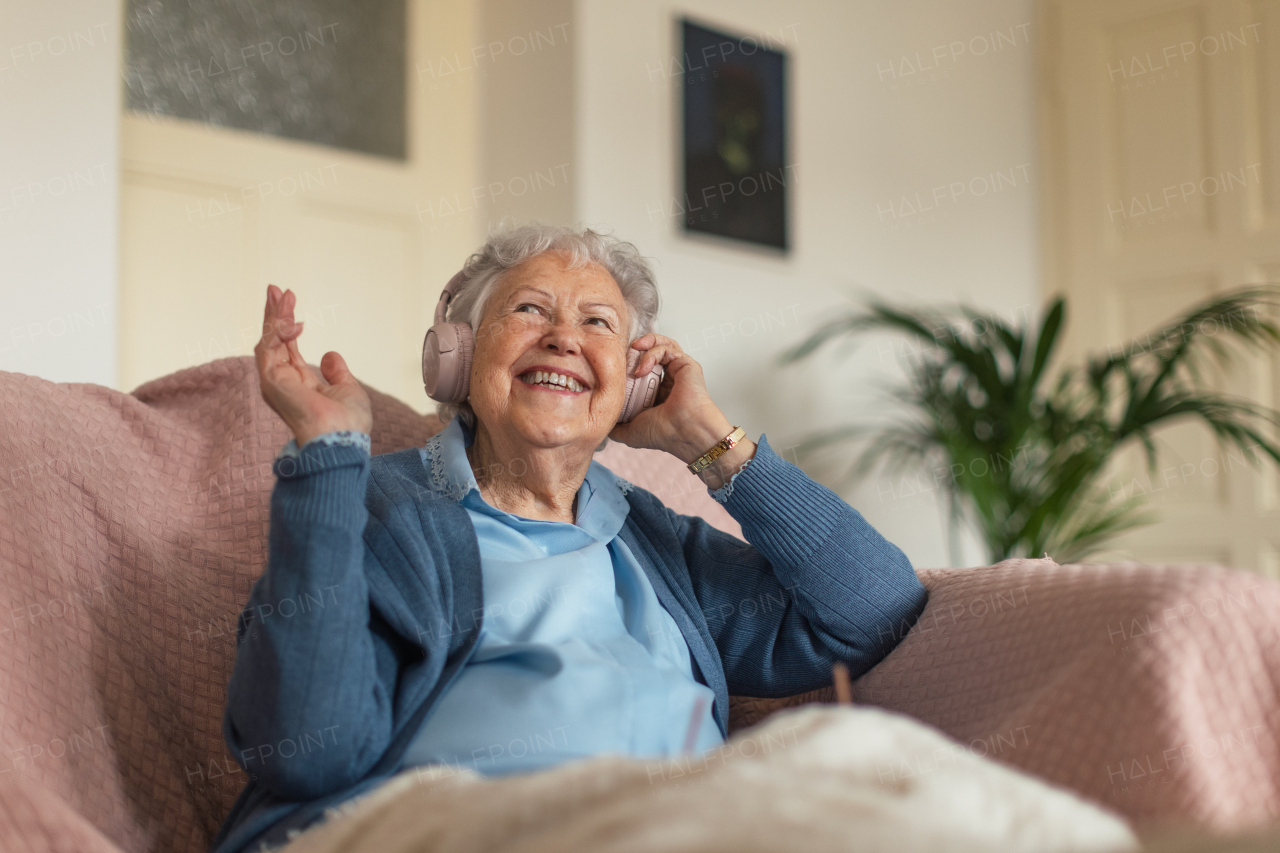 Portrait of a senior woman sitting at home and calling. Eldery woman talking on smartphone.