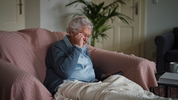 Video of a senior woman sitting at home and calling. Eldery woman talking on smartphone.