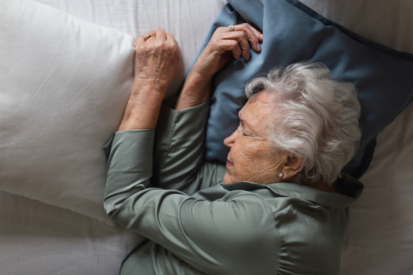 Senior woman sleeping in her bed, high angle view.