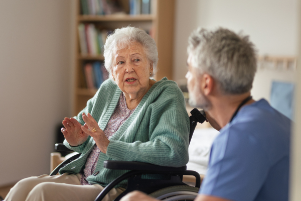 Caregiver doing regular check-up of senior client in her home.