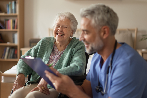 Caregiver doing regular check-up of senior client in her home.