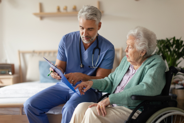 Caregiver doing regular check-up of senior client in her home.