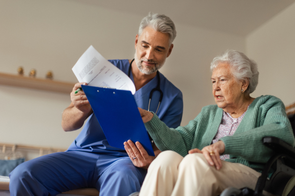 Caregiver doing regular check-up of senior client in her home.