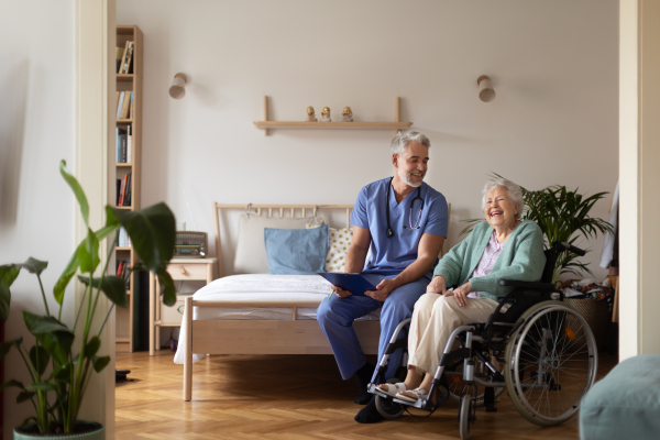 Caregiver doing regular check-up of senior client in her home.