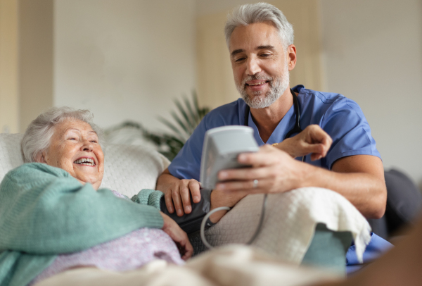 Caregiver doing regular check-up of senior client in her home.