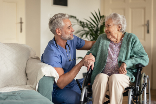 Caregiver doing regular check-up of senior client in her home.