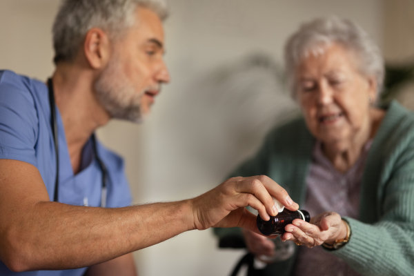 Caregiver doing regular check-up of senior client in her home.