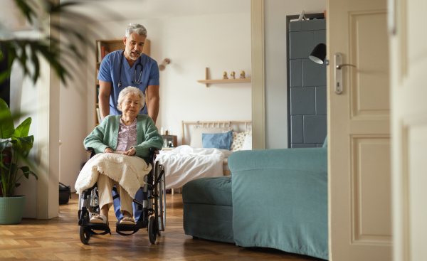 Caregiver doing regular check-up of senior client in her home.