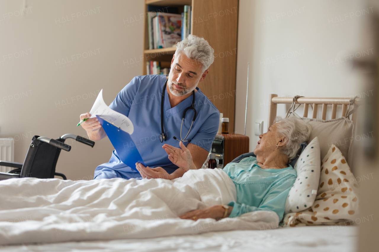 Caregiver doing regular check-up of senior client in her home.