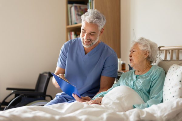 Caregiver doing regular check-up of senior client in her home.