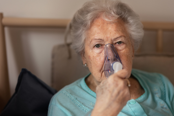 Portrait of a senior woman with inhaller, healthcare concept. Close-up of senior woman patient with oxygen mask.