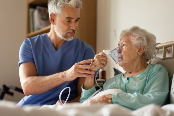 Caregiver doing regular check-up of senior client in her home.