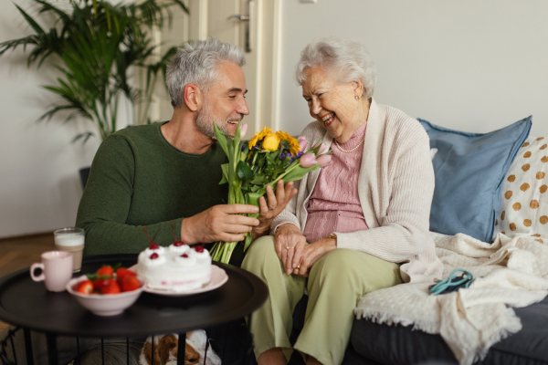 Mature man visiting his senior mother at her home.