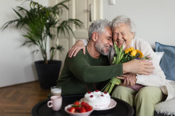 Mature man visiting his senior mother at her home.