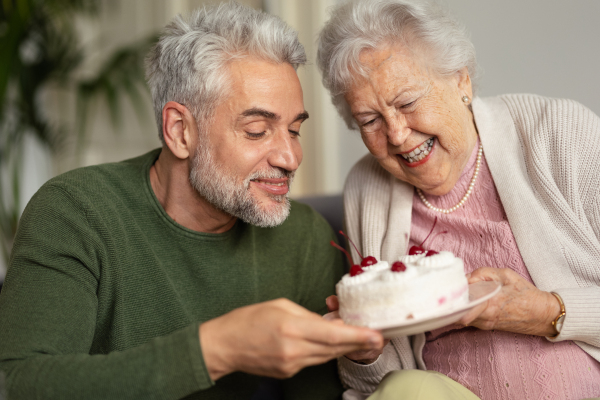 Mature man visiting his senior mother at her home.