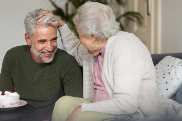 Mature man and senior woman spending quality time together. Adult son enjoys spending time with his elderly mother.